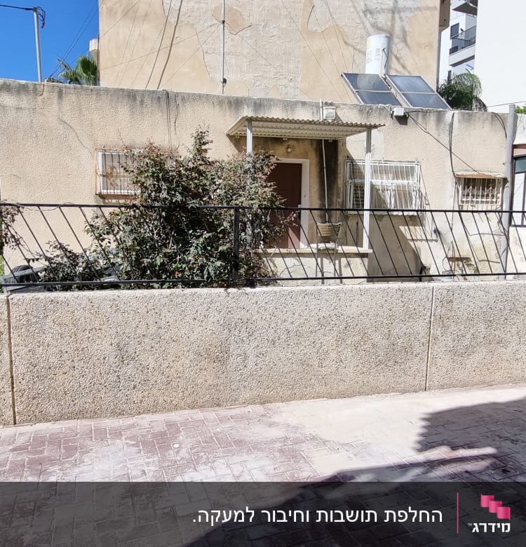 גדר מתכת שחורה עם צמחייה ברקע